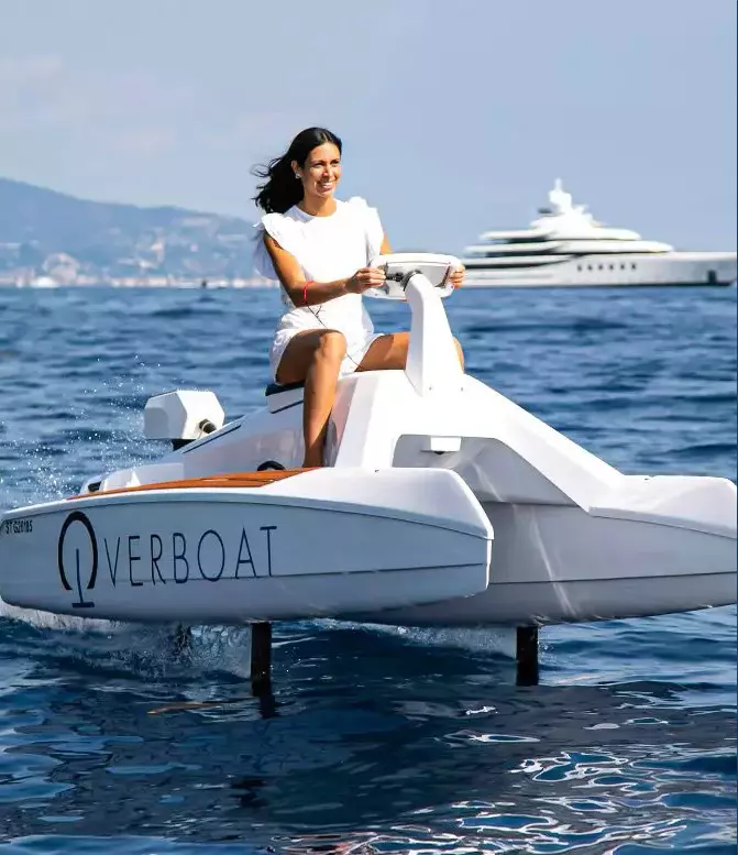 Girl in a white dress smiling while driving an Overboat